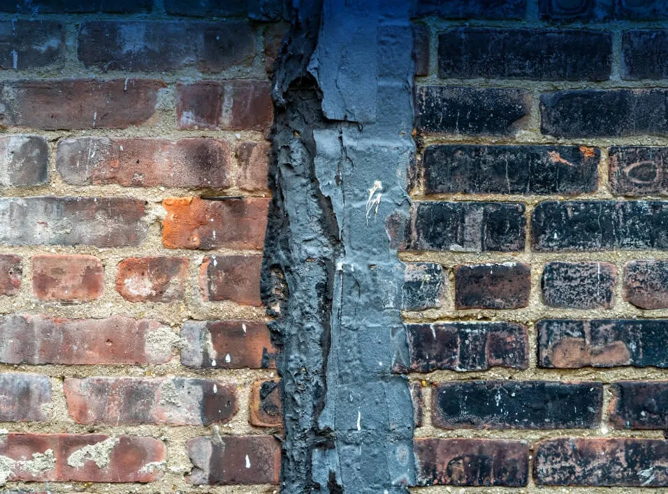 Damaged wall vs cleaned wall side by side demonstrating the benefits of Dry Ice Blasting