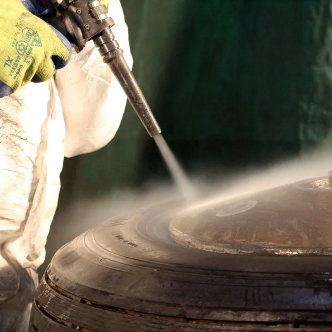 Side view photograph of Dry Ice Blasting technician cleaning a wheel.
