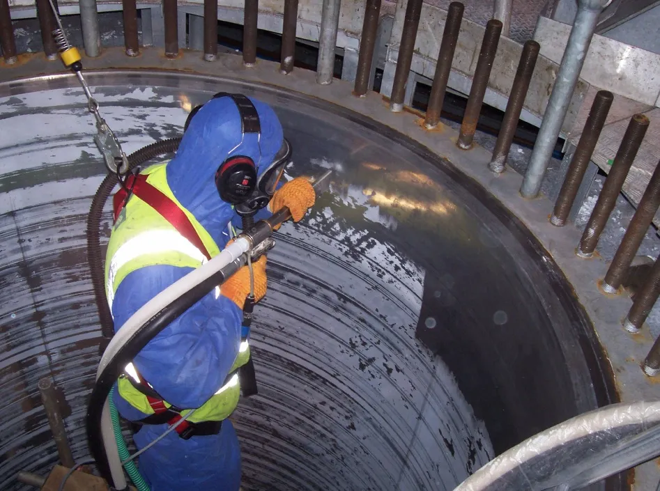Dry Ice Blast Cleaning operative cleaning a chemical vat.